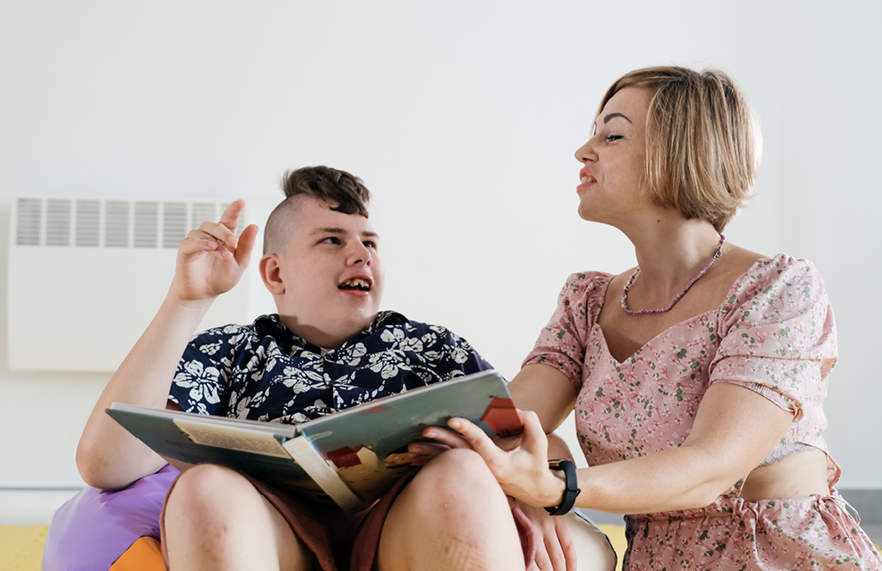 Support worker helping child to read in a residential setting